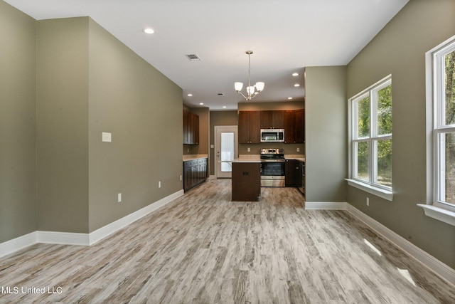 kitchen featuring a kitchen island, light hardwood / wood-style flooring, stainless steel appliances, a notable chandelier, and decorative light fixtures