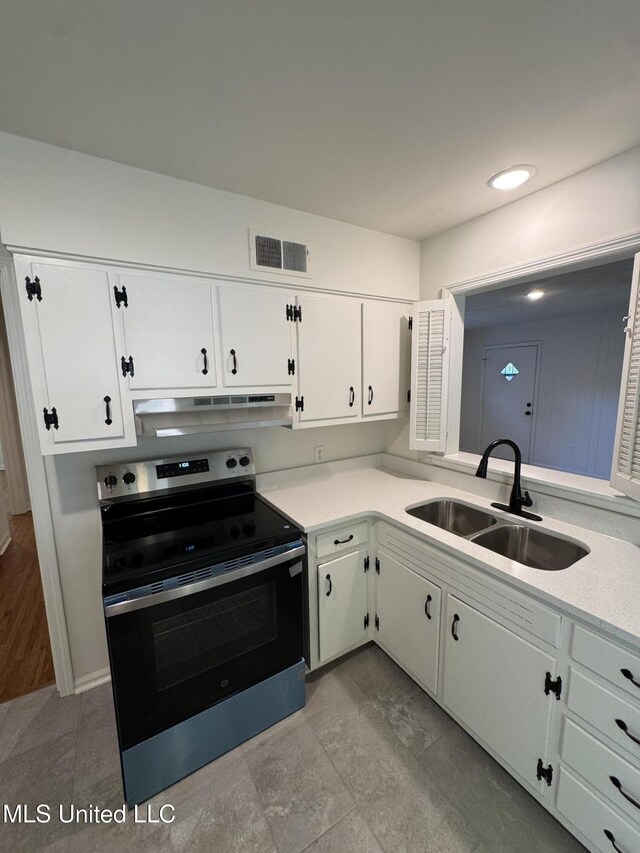 1597 Vicksburg Dr, Southaven, MS 38671 - kitchen featuring range with electric cooktop, a sink, under cabinet range hood, light countertops, and white cabinetry