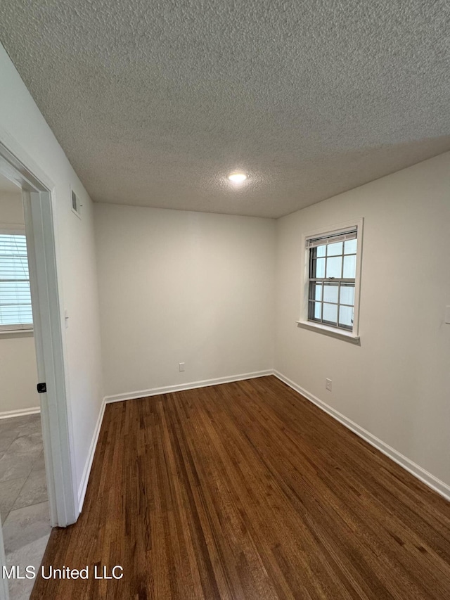 1597 Vicksburg Dr, Southaven, MS 38671 - spare room featuring a textured ceiling, dark wood-style floors, and baseboards
