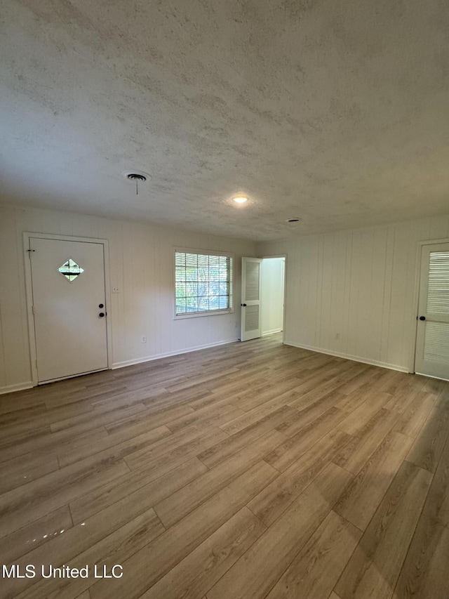 1597 Vicksburg Dr, Southaven, MS 38671 - unfurnished living room featuring wood finished floors, a textured ceiling, and baseboards