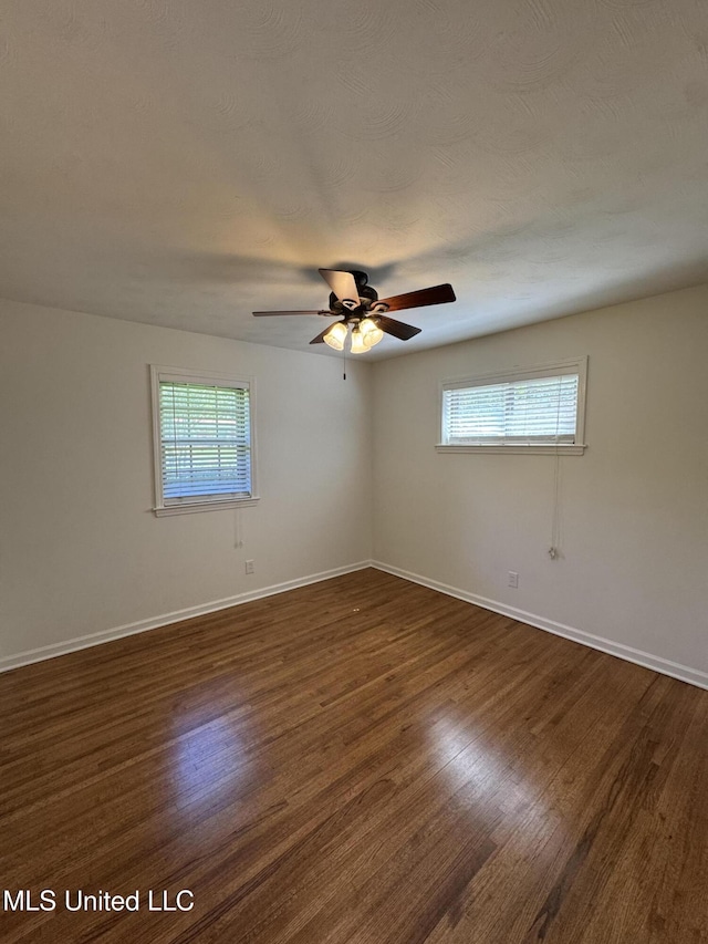 1597 Vicksburg Dr, Southaven, MS 38671 - unfurnished room featuring healthy amount of natural light, dark wood-style floors, baseboards, and a ceiling fan