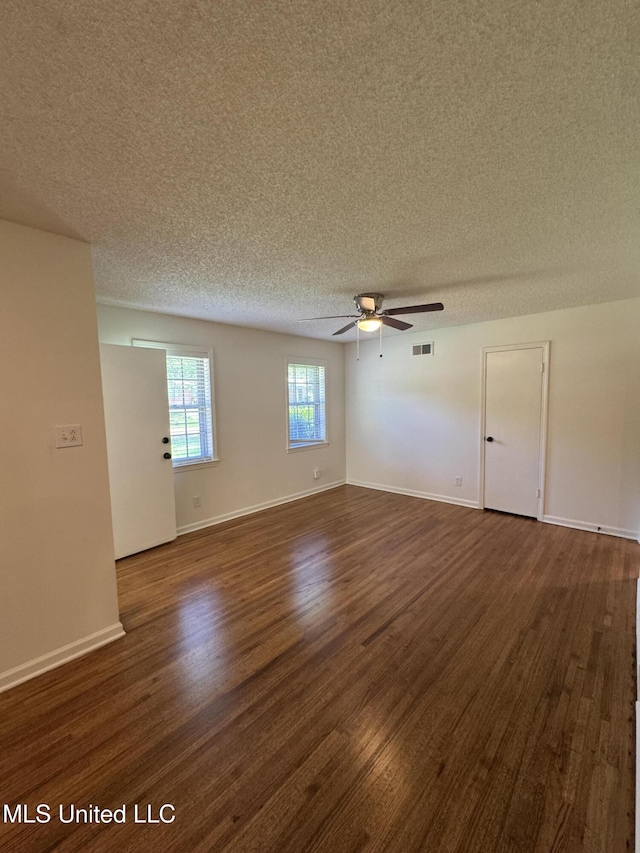 1597 Vicksburg Dr, Southaven, MS 38671 - empty room featuring a textured ceiling, dark wood-type flooring, a ceiling fan, and baseboards