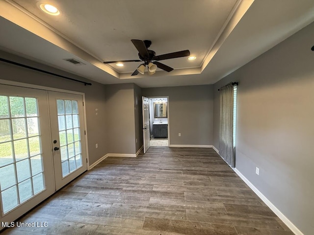 22090 Rayvan Ln, Kiln, MS 39556 - empty room with a tray ceiling, french doors, dark wood-type flooring, a ceiling fan, and recessed lighting