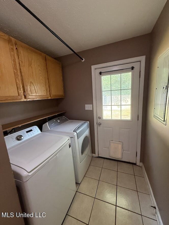 22090 Rayvan Ln, Kiln, MS 39556 - washroom featuring washer and clothes dryer, cabinet space, light tile patterned floors, and electric panel