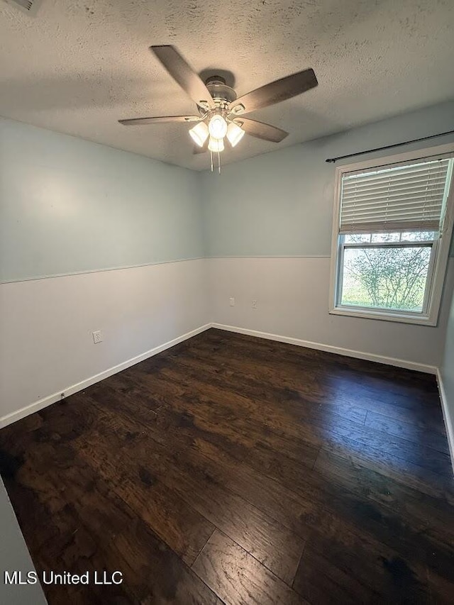 22090 Rayvan Ln, Kiln, MS 39556 - empty room featuring a textured ceiling, dark wood finished floors, and a ceiling fan