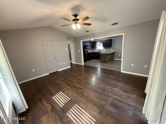 22090 Rayvan Ln, Kiln, MS 39556 - unfurnished living room featuring a ceiling fan, dark wood finished floors, and vaulted ceiling