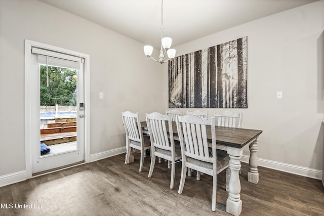 dining room with baseboards, an inviting chandelier, and wood finished floors