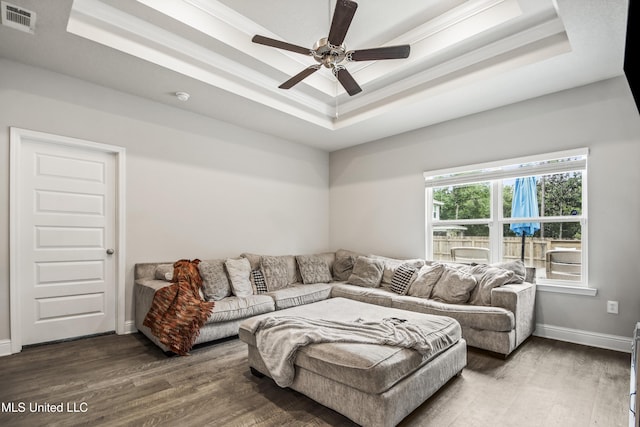 living room featuring visible vents, a raised ceiling, and wood finished floors