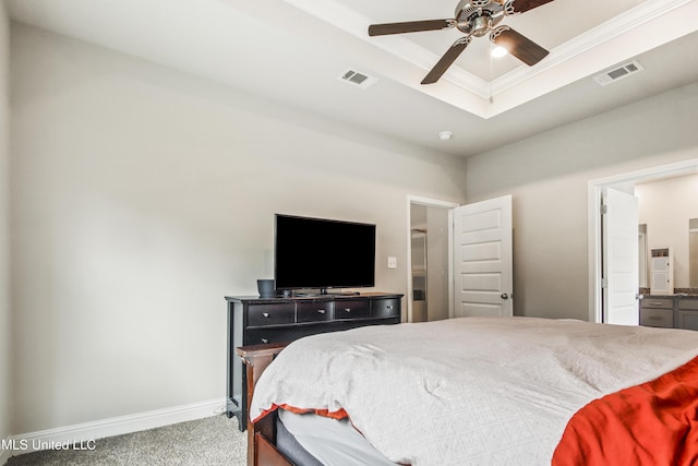 carpeted bedroom with visible vents, a raised ceiling, baseboards, and crown molding