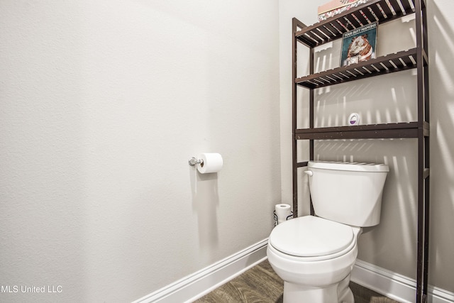 bathroom featuring toilet, wood finished floors, and baseboards