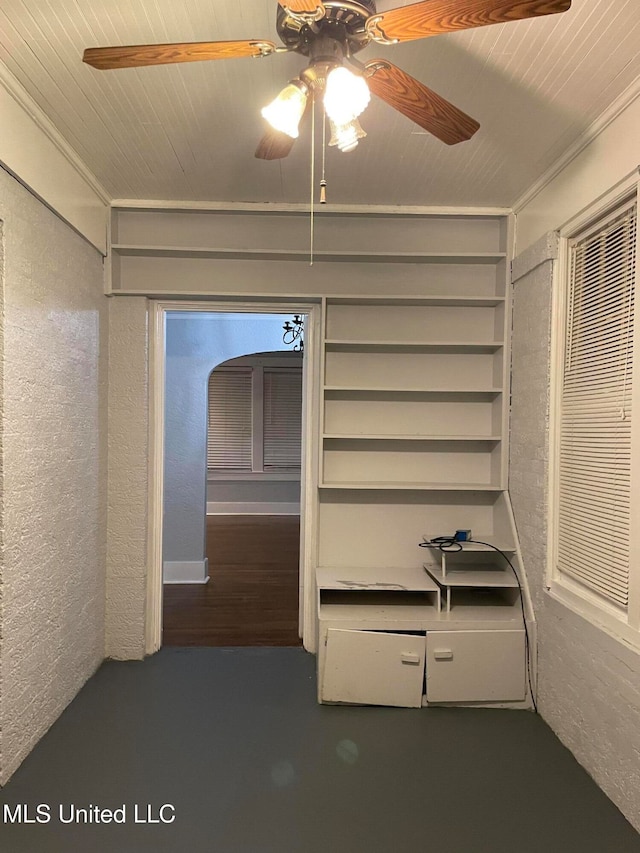 interior space with ceiling fan, crown molding, and wood ceiling