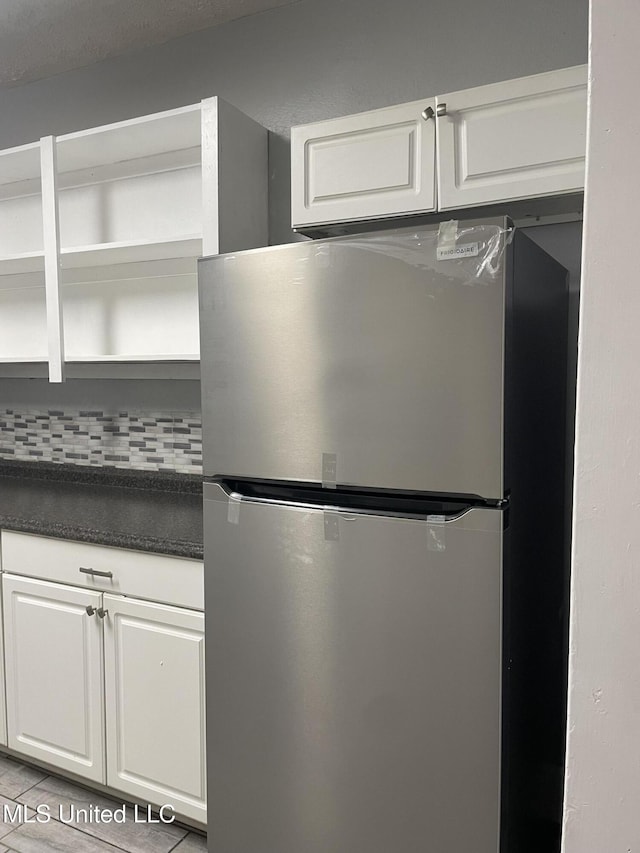 kitchen featuring white cabinetry, stainless steel fridge, and tasteful backsplash