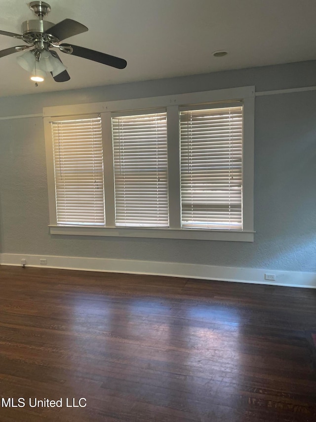 unfurnished room with ceiling fan and dark wood-type flooring