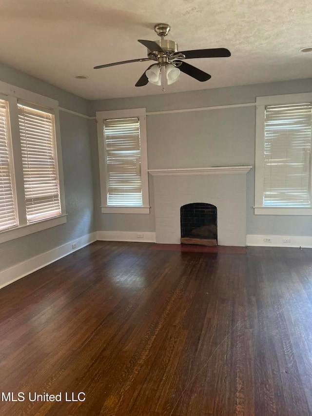 unfurnished living room featuring dark hardwood / wood-style floors, ceiling fan, and plenty of natural light