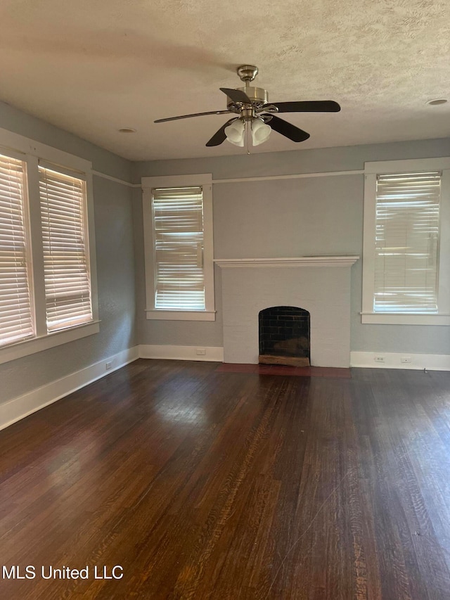 unfurnished living room featuring ceiling fan, dark hardwood / wood-style flooring, and a textured ceiling