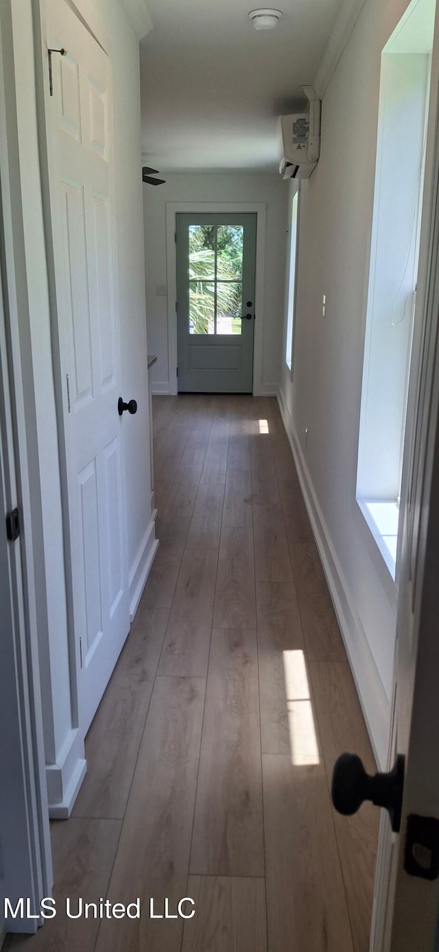 909 Sears Ave, Waveland, MS 39576 - hallway featuring hardwood / wood-style floors, a wall mounted AC, and baseboards