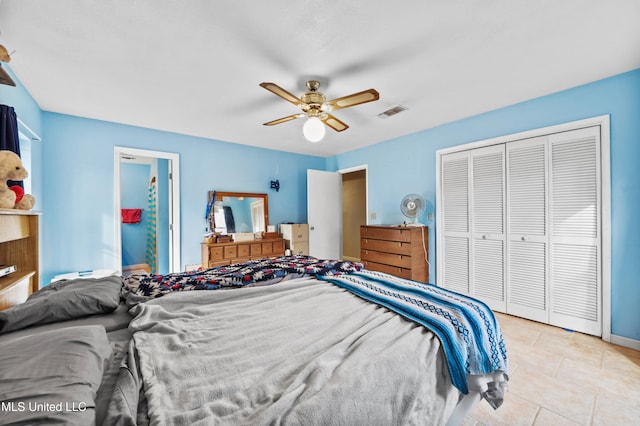 bedroom with light tile patterned floors, ceiling fan, and a closet