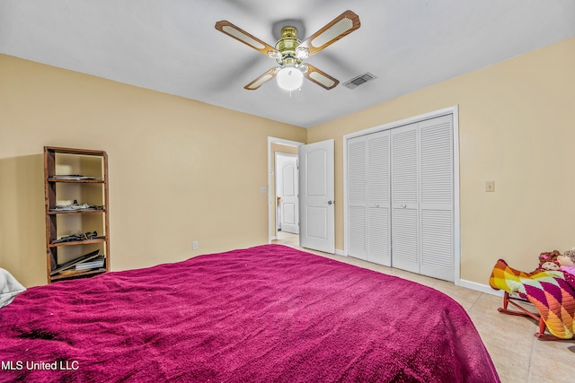 bedroom with light tile patterned floors, ceiling fan, and a closet