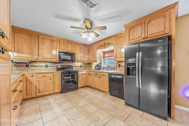 kitchen with light tile patterned floors, decorative backsplash, black appliances, and ceiling fan