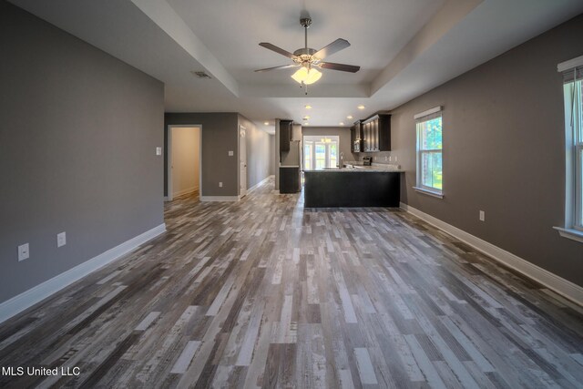 13724 Fox Hill Dr, Gulfport, MS 39503 - unfurnished living room with a tray ceiling, dark wood-style flooring, ceiling fan, baseboards, and recessed lighting