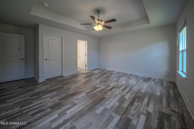 13724 Fox Hill Dr, Gulfport, MS 39503 - unfurnished bedroom with a raised ceiling, multiple windows, and wood finished floors