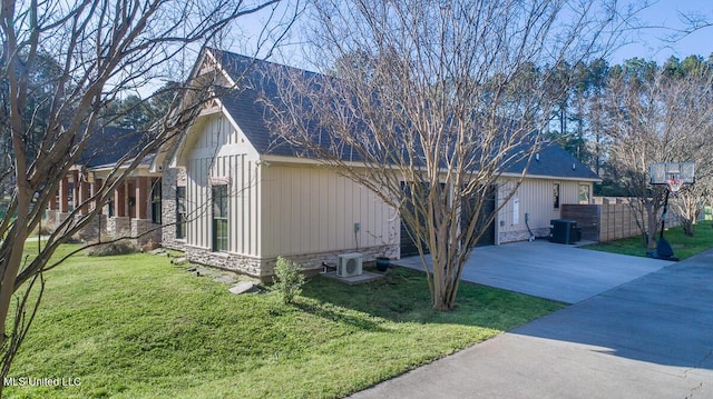 29 Club Dr, Natchez, MS 39120 - view of property exterior with stone siding, central AC unit, and a yard