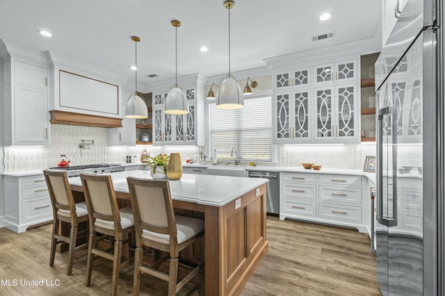 kitchen featuring visible vents, appliances with stainless steel finishes, light wood-style floors, and a sink