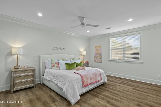 bedroom featuring visible vents, baseboards, dark wood-type flooring, and ornamental molding