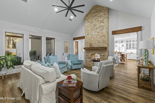 living room with visible vents, high vaulted ceiling, dark wood-style flooring, and a fireplace