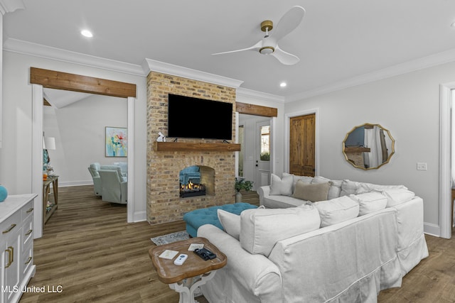 living room featuring wood finished floors, crown molding, a brick fireplace, ceiling fan, and vaulted ceiling