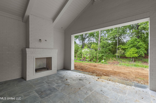 230 Parke Dr, Ridgeland, MS 39157 - unfurnished living room featuring vaulted ceiling with beams, an outdoor brick fireplace, and stone tile floors
