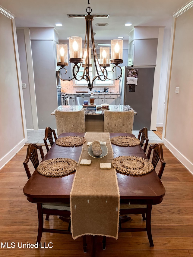 503 E Adams Ave, Greenwood, MS 38930 - dining room with a chandelier, baseboards, wood finished floors, and recessed lighting