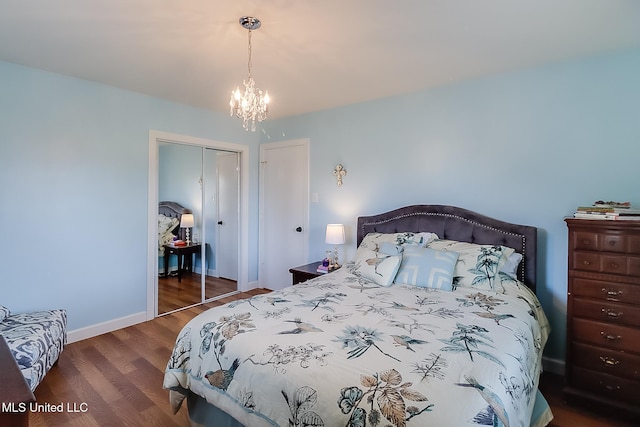 bedroom with dark wood-type flooring, a closet, and a notable chandelier