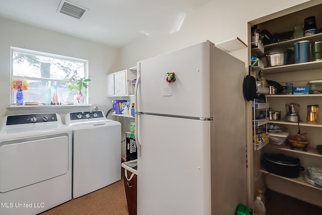 clothes washing area featuring cabinets and washing machine and dryer