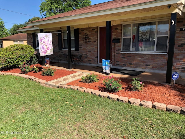 single story home with a front lawn and covered porch