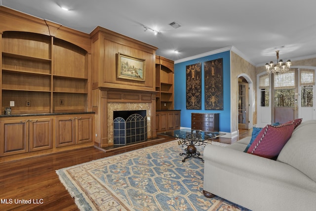 living area with visible vents, a premium fireplace, dark wood finished floors, arched walkways, and crown molding