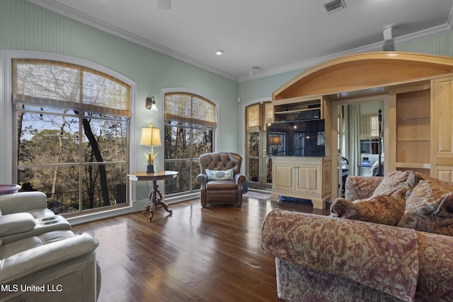 living area with visible vents, crown molding, and wood-type flooring