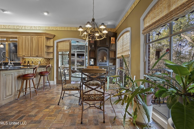 dining area featuring brick floor, arched walkways, a notable chandelier, and crown molding
