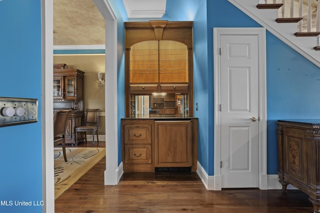 interior space with stairs, baseboards, dark wood-style flooring, and crown molding