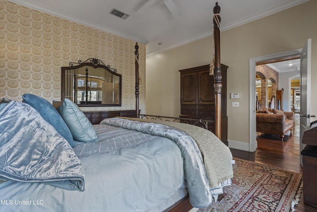 bedroom featuring visible vents, wood finished floors, crown molding, baseboards, and ceiling fan