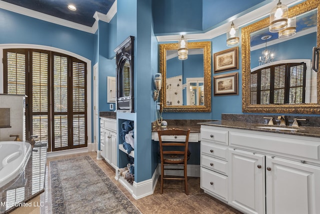 full bath with vanity, a garden tub, crown molding, and baseboards