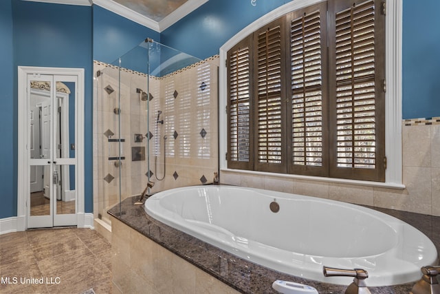 full bathroom with baseboards, a garden tub, a stall shower, and ornamental molding
