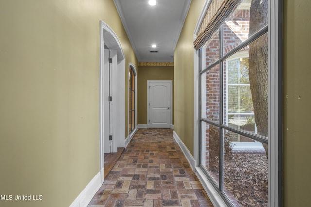 corridor with baseboards, visible vents, recessed lighting, brick floor, and crown molding