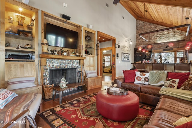 living room featuring visible vents, high vaulted ceiling, a tiled fireplace, wood finished floors, and wood ceiling