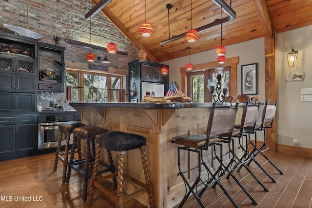 bar featuring oven, beam ceiling, hardwood / wood-style flooring, a community bar, and wood ceiling