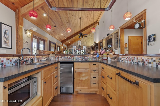 kitchen featuring dark countertops, lofted ceiling with beams, wooden ceiling, stainless steel microwave, and backsplash