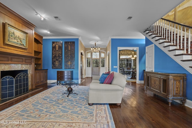 living area with a high end fireplace, visible vents, an inviting chandelier, and dark wood-style floors