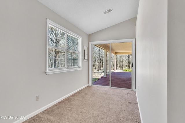 entryway with visible vents, baseboards, lofted ceiling, carpet flooring, and a textured ceiling