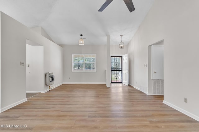 interior space with light wood-style flooring, heating unit, visible vents, and baseboards