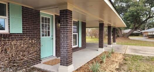 exterior space featuring brick siding and a porch